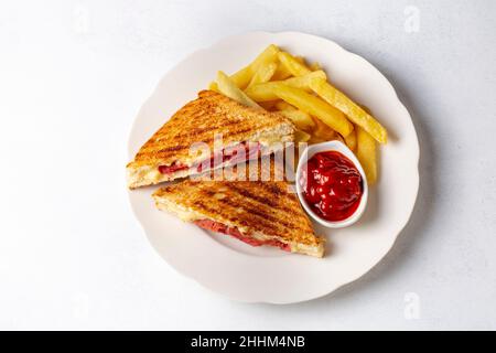 Türkischer Toast, gemischter Toast mit Cheddar-Käse, Wurst und Schinken, mit Bratkartoffeln (türkischer Name; Karisik tost) Stockfoto