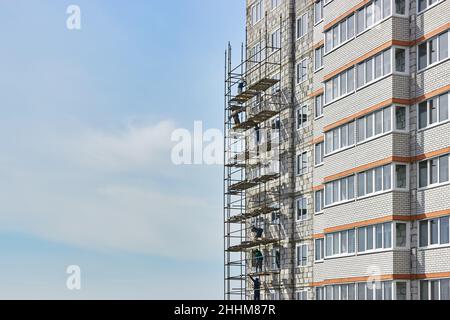 Bauherren arbeiten ohne Schutz, Versicherung. Installation von Gerüsten. Bau- und Installationsarbeiten. Konstruktion. Stockfoto