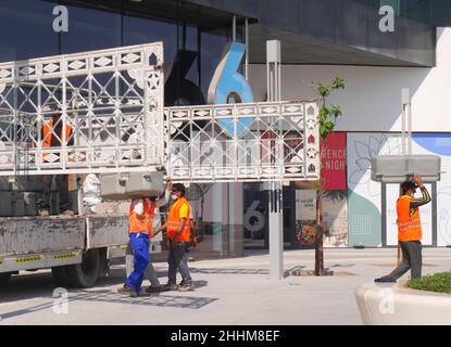 Asiatische Bauarbeiter, die einen Lastwagen entladen, Yas Bay Waterfront, Yas Island, Abu Dhabi, Vereinigte Arabische Emirate Stockfoto