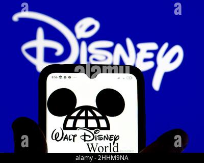 In dieser Abbildung ist das Walt Disney World-Logo auf einem Smartphone-Bildschirm mit einem Disney-Logo im Hintergrund zu sehen. Stockfoto