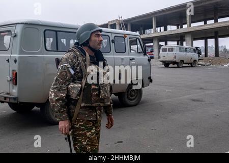 STEPANAKERT, BERG-KARABACH - 06. NOVEMBER: Ein Mitglied der Arzakh Defense Army wartet am 06. November 2020 vor dem Hauptkrankenhaus von Stepanakert, der de facto Hauptstadt der selbsternannten Republik Arzakh oder Berg-Karabach, de jure Teil der Republik Aserbaidschan. Die Kämpfe zwischen Armenien und Aserbaidschan um Berg-Karabach, auch bekannt als die Republik Arzakh, brachen Ende September in einen sechswöchigen Krieg aus, in dem sich beide Länder gegenseitig der Provokation beschuldigten, die Tausende Tote hinterließ. Stockfoto