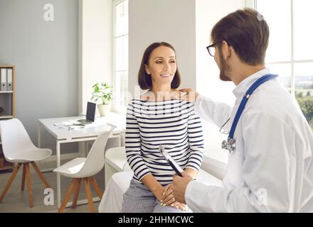 Der Arzt berührt die Schulter des Patienten für Ermutigung, Empathie und Unterstützung während der medizinischen Untersuchung Stockfoto