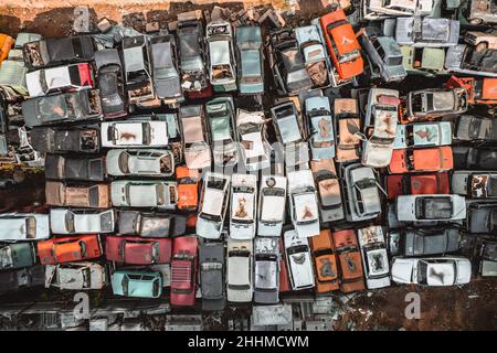 Luftaufnahme einer sowjetischen Autodumpe von einer Drohne. Schießen von oben auf Haufen rostiger Autos. Verlassene russische Autos warten auf Entsorgung und Stockfoto