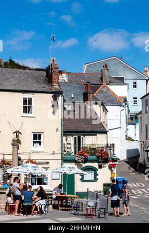 Leute, die sich vor dem Cross Key Inn in The Square, Cawsand, Cornwall treffen. Während der Covid-Pandemie war es beliebt, außerhalb von Pubs vorübergehend zu sitzen. Stockfoto