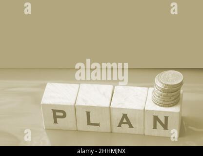 Wortplan mit Buchstaben auf Holzblöcken und Münzstapel. Geschäftsplan Stockfoto