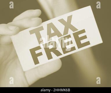 Steuerfreie Worte auf einer Karte in der Hand eines Geschäftsmannes. Steuer- und Gebührenregulierung im Geschäftskonzept Stockfoto