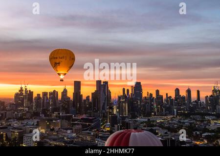 Melbourne, Australien. 24th Januar 2022. Tennis: Grand Slam - Australian Open. Heißluftballons passieren das Stadtzentrum bei Sonnenaufgang. Quelle: Frank Molter/dpa/Alamy Live News Stockfoto