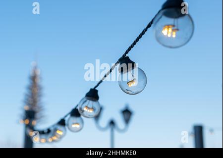 Girlande von Glühbirnen im Park. Stockfoto