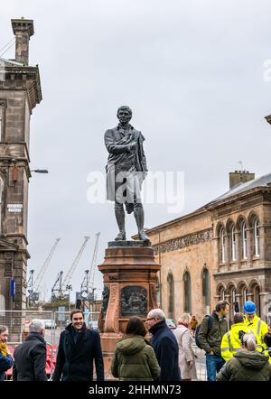 Leith, Edinburgh, Schottland, Großbritannien, 25. Januar 2022. Robert Burns Statue enthüllt: Die Statue, die 2019 für die Straßenbahnen nach Newhaven entfernt wurde, kehrt in der in der Burns Night neu restaurierten Bernard Street zurück. Die Statue wurde 1898 vom Leith Burns Club errichtet. Auf jeder Seite des Sockels befindet sich eine Tafel, die auf einem der Gedichte von Burns basiert: Der Samstagabend der Cottar, Hallowe'en, der Tod und Dr. Hornbrook und der Smiddy Stockfoto