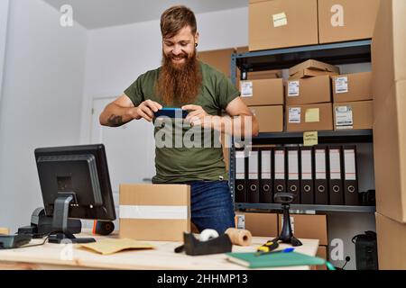 Junge Rotschopf Mann Geschäftsmann machen Foto zu verpacken im Büro Stockfoto