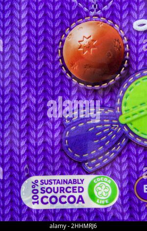 100% Kakao aus nachhaltiger Produktion - Cocoa Life Symbol CocoaLife auf einer Packung Cadbury Dairy Milk Jingly Bells Haselnusscreme-Schokolade Stockfoto