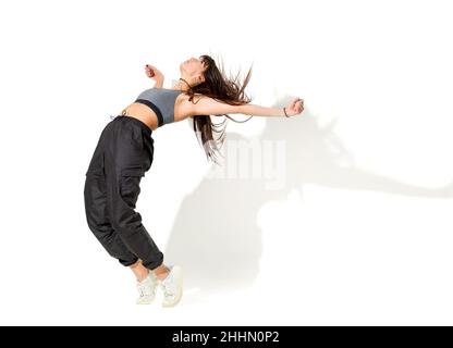 Full Body von schlanken jungen Hip Hop Tänzerin in Sportswear Durchführung Tanzbewegung in weißen Studio Stockfoto