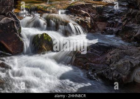 Der Fluss Coe entspringt am nordöstlichen Fuße des Buachaille Etive Beag in Schottland und fließt westlich entlang des Glen Coe. Nach dramatischen Wasserfällen am Pa Stockfoto