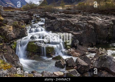 Der Fluss Coe entspringt am nordöstlichen Fuße des Buachaille Etive Beag in Schottland und fließt westlich entlang des Glen Coe. Nach dramatischen Wasserfällen am Pa Stockfoto
