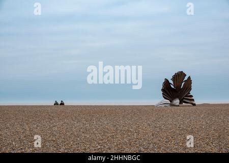 Die Shell-Skulptur am Strand von Aldeburgh mit den oberen Hälften von zwei Sitzenden, die an einem langweiligen Tag auf das Meer blicken Stockfoto