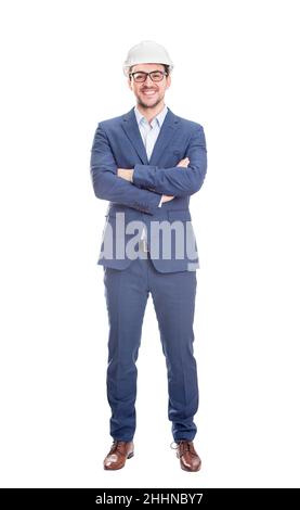 Fröhlicher und selbstbewusster Geschäftsmann Ingenieur, hält die Arme gekreuzt mit schützendem Hardhat Lächeln Blick auf Kamera isoliert über weißem Hintergrund. Stockfoto