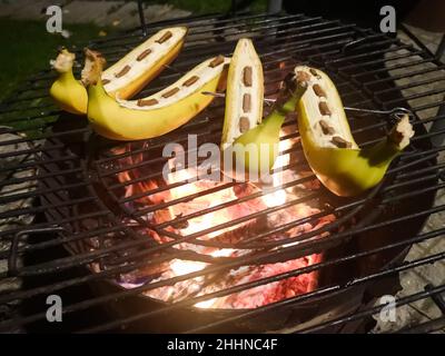 Beim Buschbasteln im Sommer leckere Bananen mit Schokolade am Feuer kochen Stockfoto