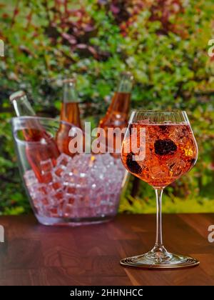 Flaschen und ein Glas Apfelmost mit Brombeergeschmack, auf einem Gartenhintergrund, flacher Fokus Stockfoto