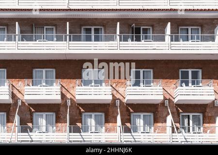 Außenansicht eines Backsteingebäudes mit Whiteboard-Balkonen und Glastüren. Eine Hotelfassade des Resorts mit Balkonen, keine Menschen. Vorderansicht eines Elevati Stockfoto