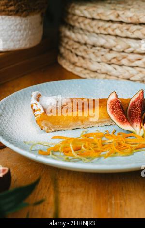 Eine vertikale Nahaufnahme des orangefarbenen Käsekuchen-Tarte mit Abb. Stockfoto