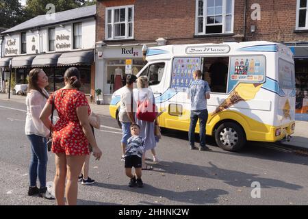 Soziale Distanzierung im Vereinigten Königreich; Menschen, die während der COVID 19-Pandemie in Harpenden Hertfordshire in einem Eiswagen Schlange stehen, um Eis zu kaufen Stockfoto