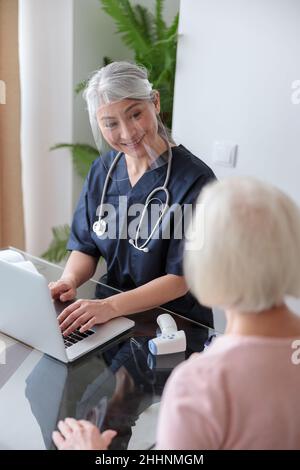 Ärztin besucht ältere Patienten zu Hause Stockfoto