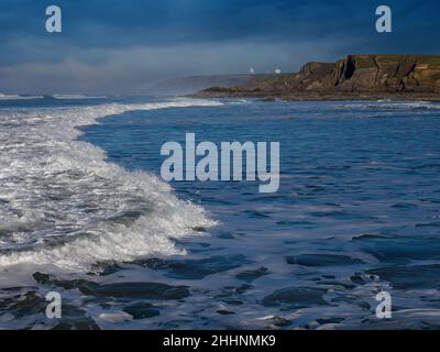 Blick entlang der Küste von Bude mit den GCHQ-Satellitenschüsseln in der Ferne, Bude, Cornwall, Großbritannien Stockfoto