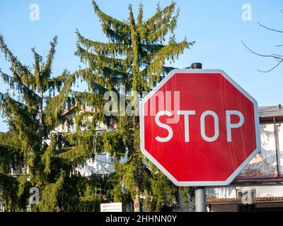 Halten Sie rote Straßenschild auf grünen Bäumen Hintergrund Stockfoto