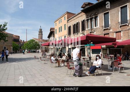 Die Leute sitzen in einer Bar auf dem Santa Margherita Platz in Venedig. Stockfoto