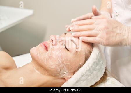 Gesichtsmassage vorbereiten. Hände des Arztes. Hübsche weibliche Patientin. Schönheitsbehandlung Stockfoto