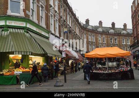 London, Großbritannien, 25. Januar 2022: Auf der Electric Avenue in Brixton kaufen Menschen Lebensmittel in Geschäften und Marktständen, die der Vielfalt der lokalen Bevölkerung gerecht werden. Die Kosten für Grundnahrungsmittel sind stark gestiegen, und es gibt Befürchtungen, wie die Lebenshaltungskosten die ärmeren Haushalte im ganzen Land beeinflussen werden. Anna Watson/Alamy Live News Stockfoto