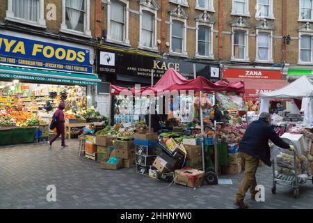 London, Großbritannien, 25. Januar 2022: Auf der Electric Avenue in Brixton kaufen Menschen Lebensmittel in Geschäften und Marktständen, die der Vielfalt der lokalen Bevölkerung gerecht werden. Die Kosten für Grundnahrungsmittel sind stark gestiegen, und es gibt Befürchtungen, wie die Lebenshaltungskosten die ärmeren Haushalte im ganzen Land beeinflussen werden. Anna Watson/Alamy Live News Stockfoto