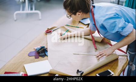 Schneiden Sie im Studio weibliche Designer-Tracing auf Bastelpapier Stockfoto