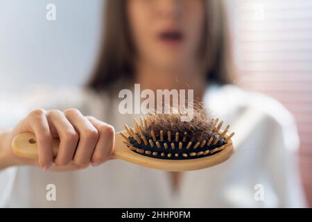 Haarverlustkonzept. Besorgte Frau Hält Nach Dem Bürsten Den Kamm Voll Gefallener Haare Stockfoto