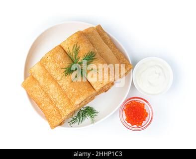 Gefüllte Pfannkuchen auf einem weißen Teller mit Dill, Sauerrahm und rotem Kaviar. Stockfoto