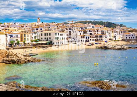 Blick auf den Strand von Calella de Palafurgell, wo Badegäste im Meer baden und die Fischerboote im Sand ruhen, Costa Brava, Katalonien, Spanien Stockfoto