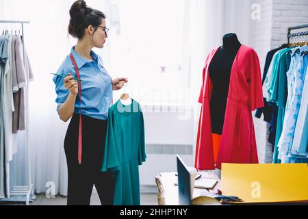 Frau Näherin mit Kleid auf Kleiderbügel Stockfoto