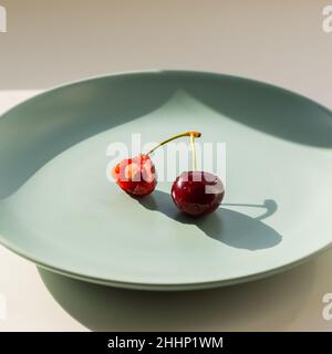Eine rote Erdbeere auf dem grünen Teller. Gesundes Lifestyle-Konzept. Stockfoto