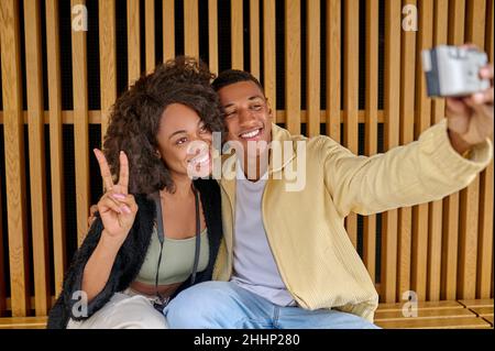 Mann, der Selfie mit Frau macht und eine Freiheitsgeste zeigt Stockfoto
