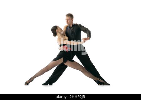 Dynamisches Porträt von flexiblen jungen Tänzern, die argentinischen Tango tanzen, isoliert auf weißem Studiohintergrund. Künstler in schwarzen Bühnenkostümen Stockfoto