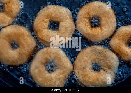 Hausgemachte Donuts Braten in Gusseisen Pfanne im Freien. Stockfoto