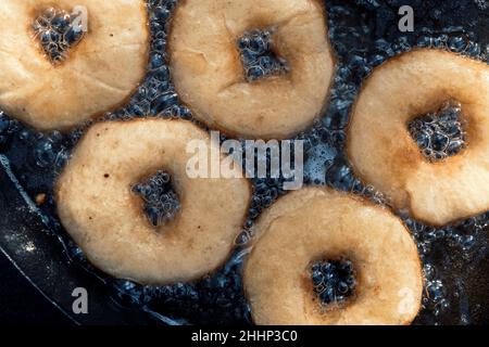 Nahaufnahme von hausgemachten Donuts Braten in Gusseisen Pfanne im Freien auf dem Campingplatz. Stockfoto