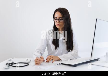 Porträt einer jungen Ärztin, die ein Rezept schreibt Stockfoto