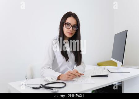 Ärztin, die im Büro mit medizinischen Dokumenten arbeitet Stockfoto