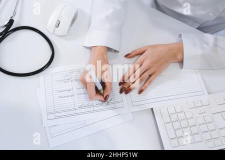 Nahaufnahme der Ärztin Hände füllen Papierkram Stockfoto
