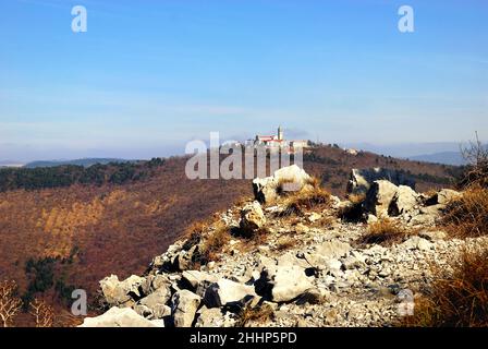 Monte Santo (Skalnica) vom Kamm der Sabotin aus gesehen. Monte Santo war das Theater blutiger Schlachten während des Ersten Weltkriegs. Die Kirche auf der Spitze wurde von der italienischen Artillerie, die auf dem Berg Sabotin aufgestellt wurde, zerstört. Es wurde in den Jahren zwischen 1924 und 1928 wieder aufgebaut. Stockfoto