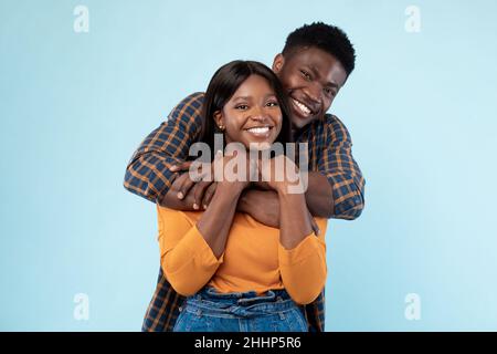 Afroamerikanische Dame kuschelt mit ihrem glücklichen Mann Stockfoto