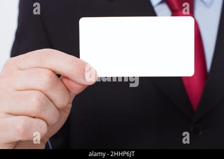 Vorlage und leere Visitenkarte in der Hand des Mannes. Selektiver Fokus Stockfoto