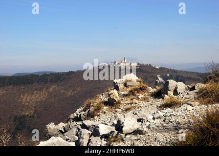 Monte Santo (Skalnica) vom Kamm der Sabotin aus gesehen. Monte Santo war das Theater blutiger Schlachten während des Ersten Weltkriegs. Die Kirche auf der Spitze wurde von der italienischen Artillerie, die auf dem Berg Sabotin aufgestellt wurde, zerstört. Es wurde in den Jahren zwischen 1924 und 1928 wieder aufgebaut. Stockfoto