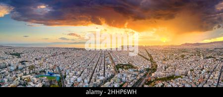 Luftdrohne Panoramablick auf die griechische Hauptstadt Athen bei Sonnenuntergang mit einem Himmel bedeckt mit Sturmwolken, Griechenland, Europa. Blick auf die Stadt von oben Stockfoto